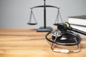 A gavel and stethoscope on a table, symbolizing the intersection of law and healthcare.