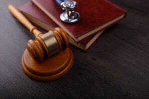 A gavel, stethoscope, and legal books on a table, symbolizing the work of a child injury lawyer.