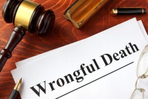 Document titled 'Wrongful Death' on a wooden desk with a gavel, glasses, and a pen.