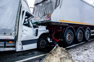 Severe collision between a truck and a van on a snowy road, resulting in major damage.