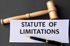 Text 'STATUTE OF LIMITATIONS' printed on white paper against a dark background, accompanied by a judge's gavel.